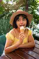 Free photo medium shot hispanic woman eating ice cream