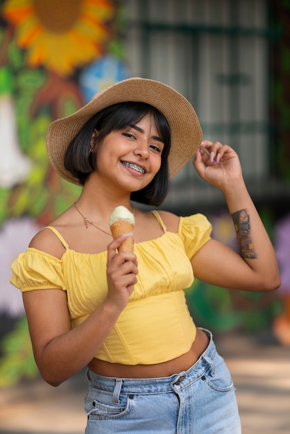 Free photo medium shot hispanic woman eating ice cream