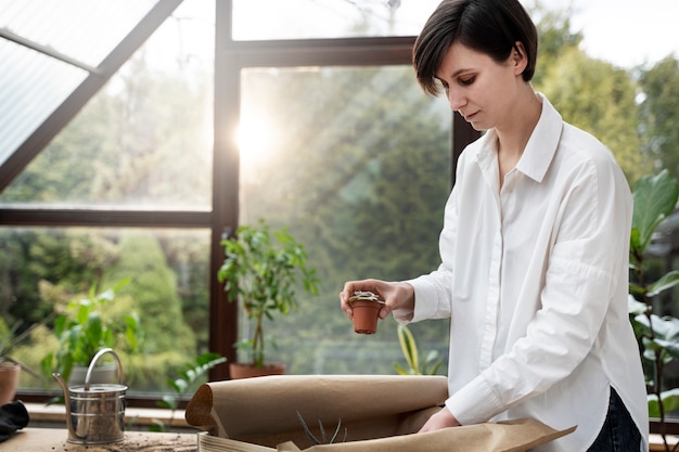 小さな鉢植えの植物を保持しているミディアムショット