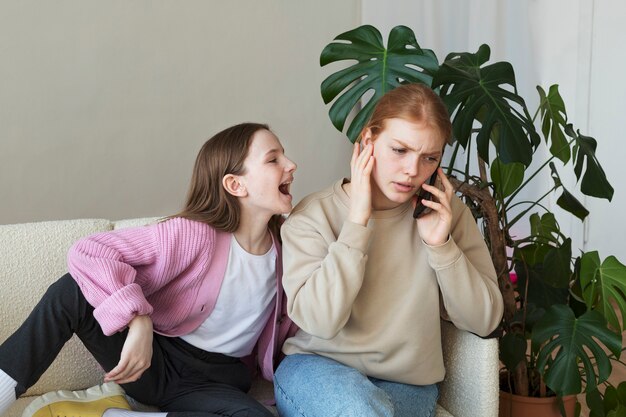 Medium shot hyperenergetic girl bothering woman