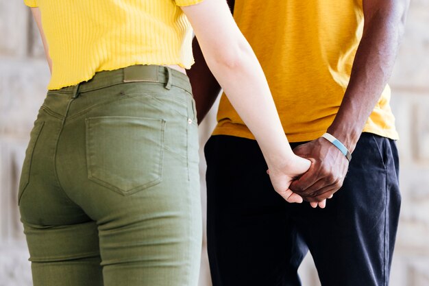 Medium shot of interracial couple holding hands