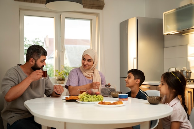 Foto gratuita famiglia islamica di tiro medio a tavola