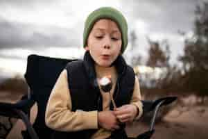 Free photo medium shot kid blowing at fire