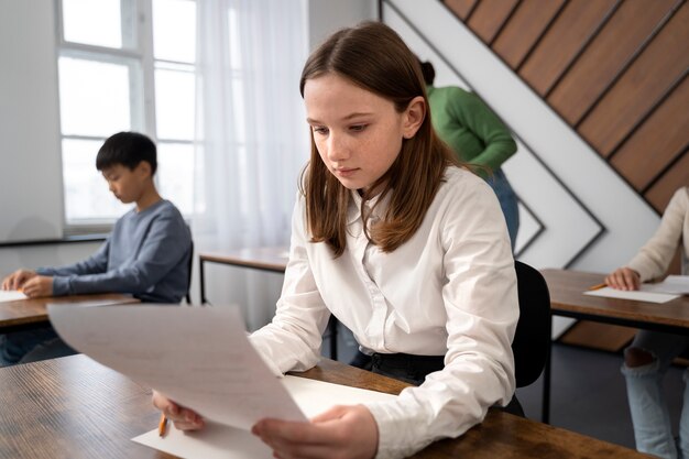 学校のテストで不正行為をするミディアム ショットの子供