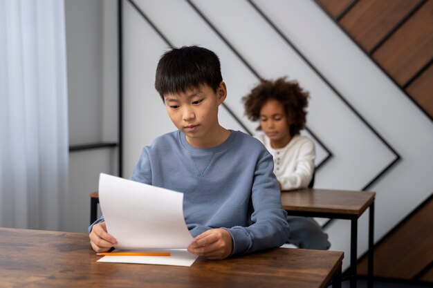 学校のテストで不正行為をするミディアム ショットの子供