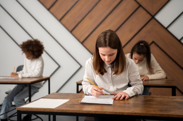 Foto gratuita ragazzo di tiro medio che tradisce al test scolastico