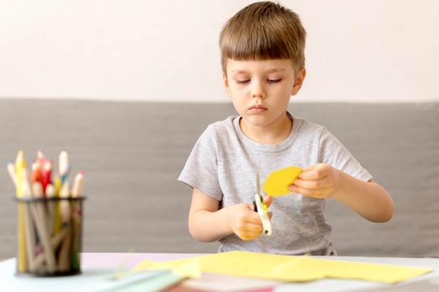 Medium shot kid cutting paper