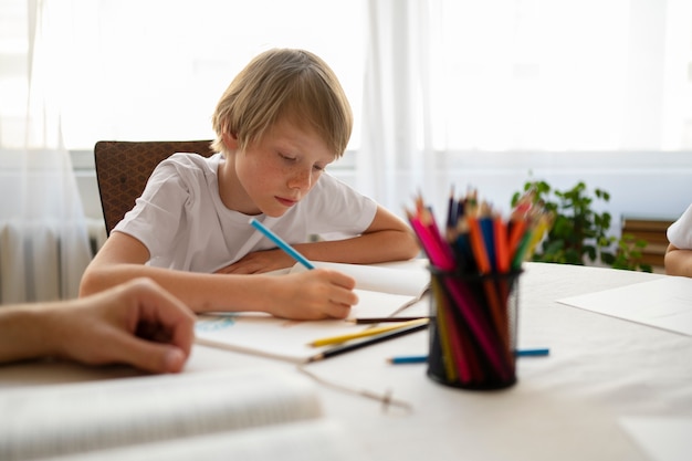 Free photo medium shot kid drawing at school