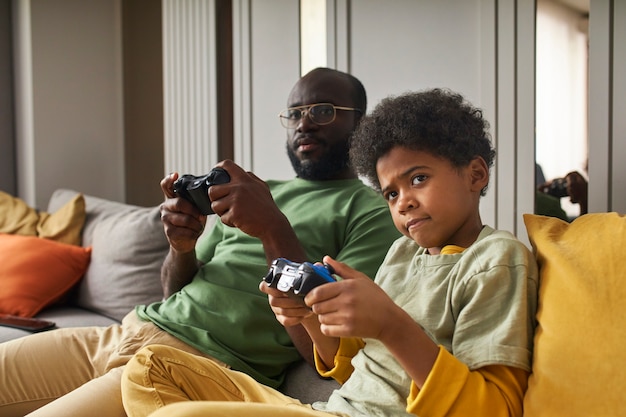 Free photo medium shot kid and father playing game