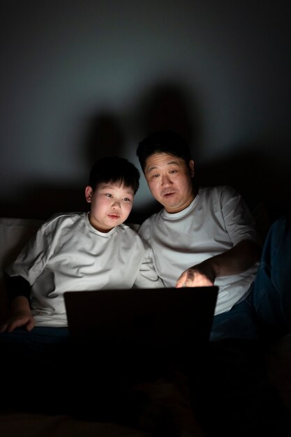 Medium shot kid and father watching movie
