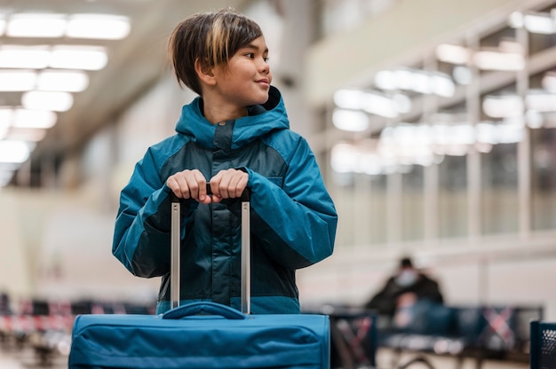 Free photo medium shot kid holding luggage