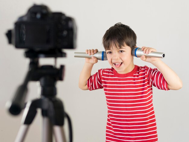 Medium shot kid holding microphones