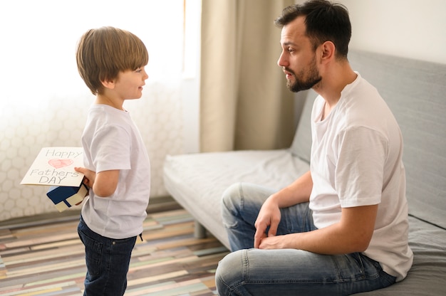 Medium shot kid holding surprise for father