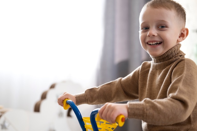 Free photo medium shot kid holding tricycle handlebars