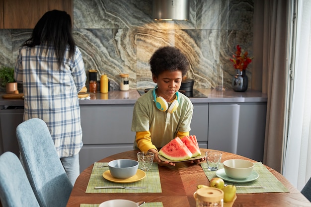 Medium shot kid holding watermelon plate