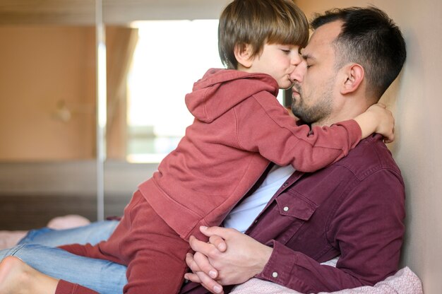 Средний выстрел ребенок целует отца
