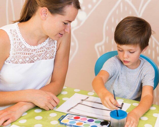 テーブルでミディアムショットの子供絵画