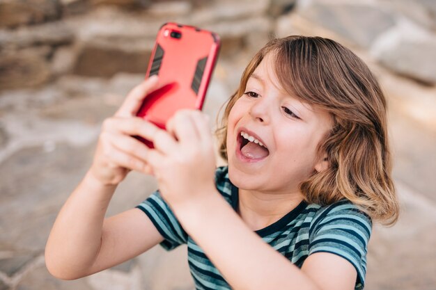 Средний снимок ребенка, играющего на телефоне