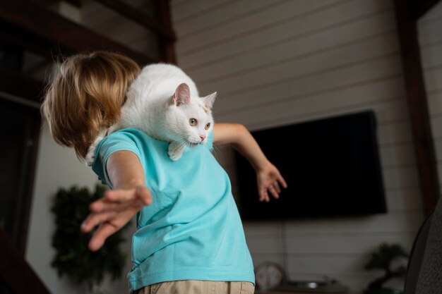 Medium shot kid playing with cat