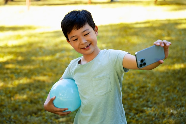 Бесплатное фото Ребенок среднего роста позирует с мячом