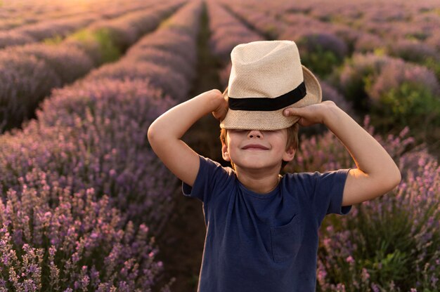 Bambino del colpo medio che posa con il cappello