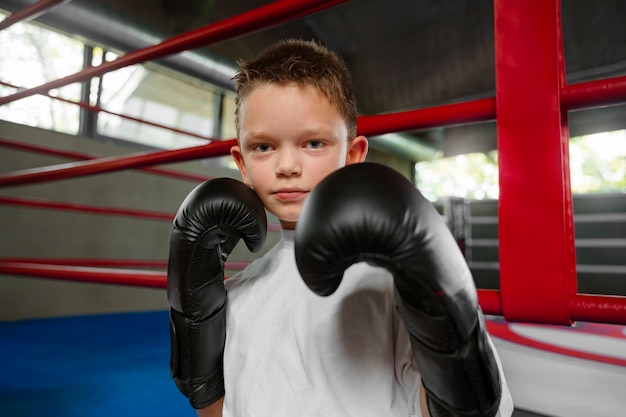 Free photo medium shot kid practicing boxing