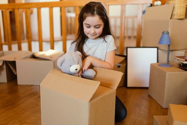 Free photo medium shot kid sitting on floor with toy