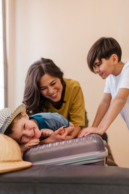 Free photo medium shot kid sitting on luggage