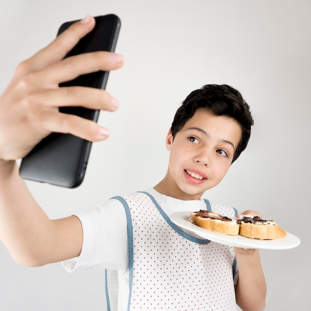 Ragazzo di tiro medio prendendo selfie