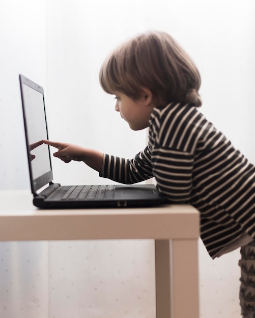 Free photo medium shot kid touching laptop