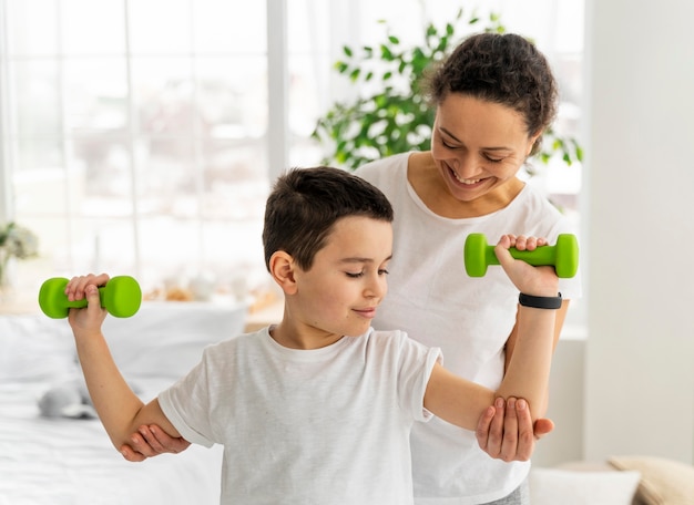 Free photo medium shot kid training with dumbbells