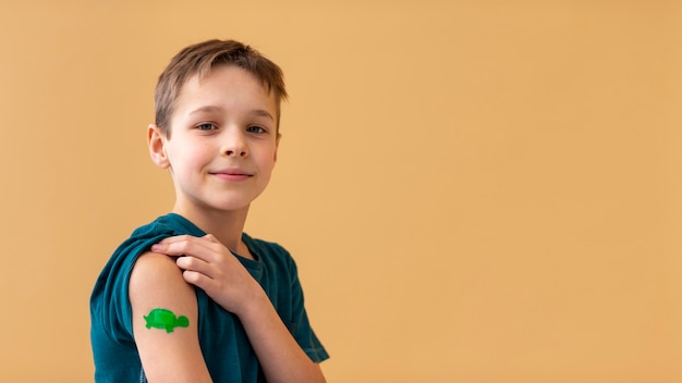 Free photo medium shot kid wearing band aid