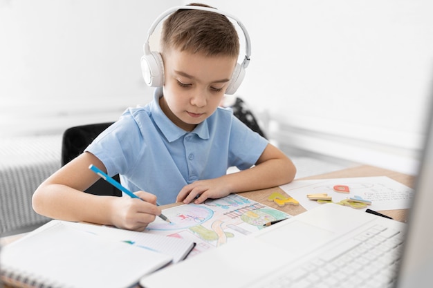 Medium shot kid with headphones drawing