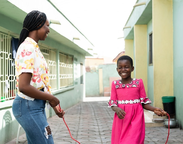 Medium shot kid and woman with jumping rope