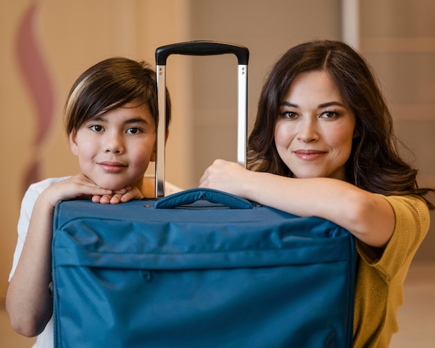 Medium shot kid and woman with luggage