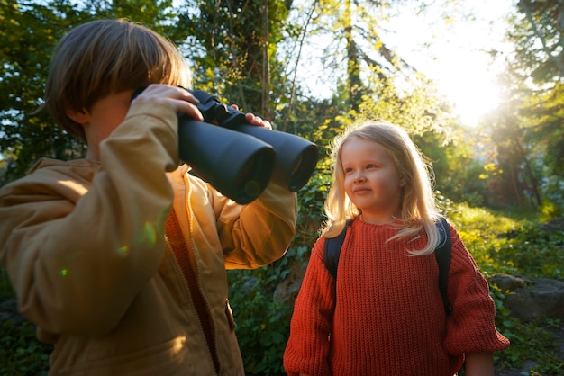 Foto gratuita bambini di tiro medio che esplorano insieme la natura