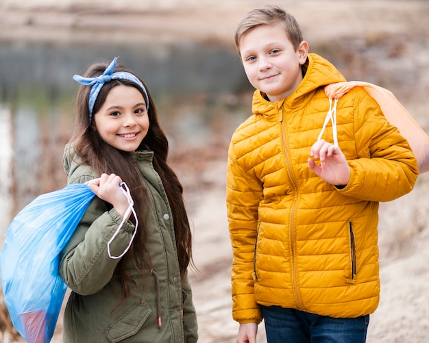 Medium shot of kids holding plastic bag