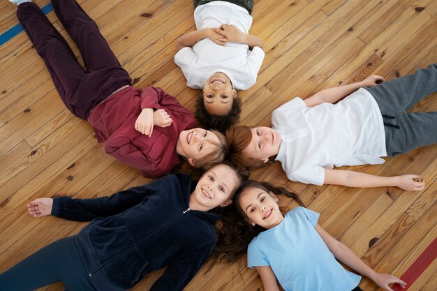 Medium shot kids laying on floor top view