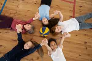 Foto gratuita bambini di tiro medio sdraiati sul pavimento della palestra