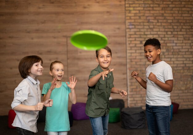 Medium shot kids playing with frisbee