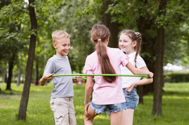 ミディアムショットの子供たちがフラフープで遊んで