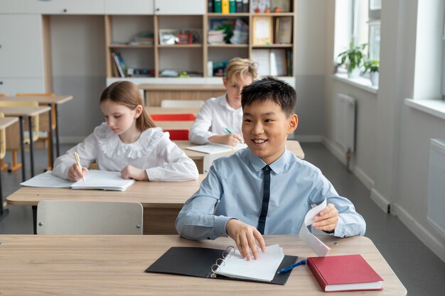 Medium shot kids sitting at school