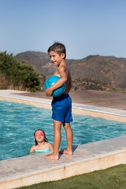 Free photo medium shot kids at swimming pool