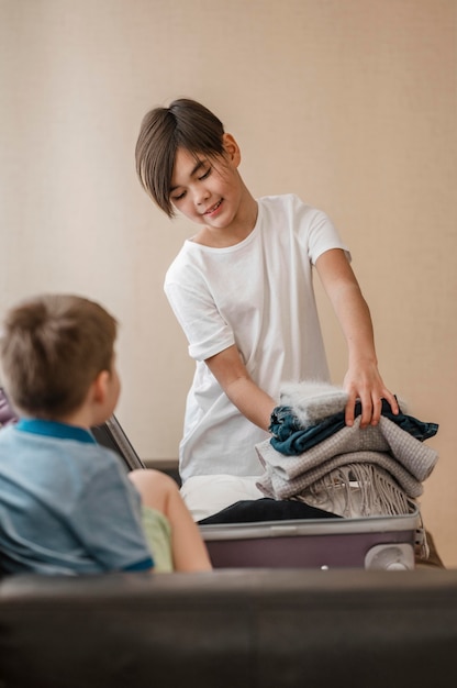 折りたたまれた服を着たミディアムショットの子供たち