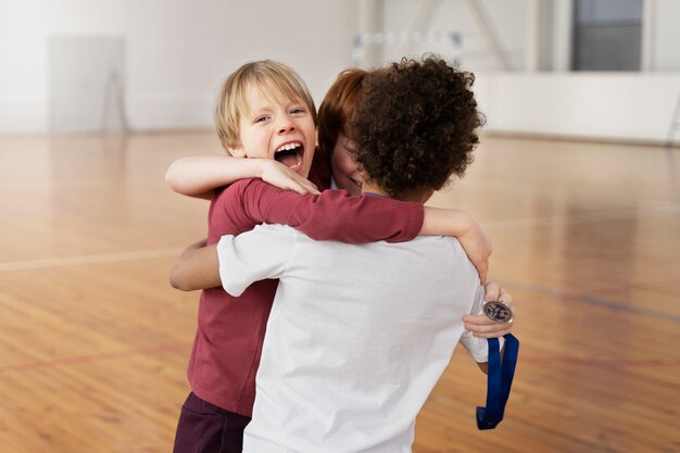 Medium shot kids with medal hugging