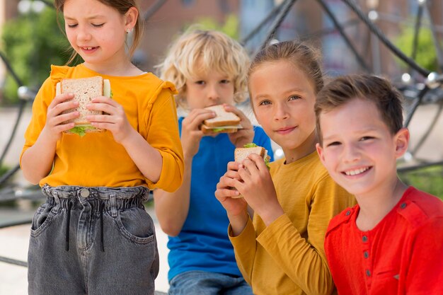 Medium shot kids with sandwiches