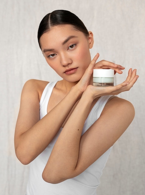 Medium shot korean woman posing with face cream