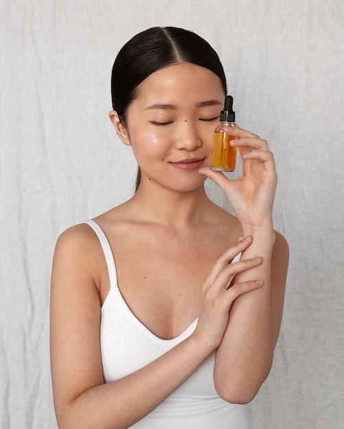 Medium shot korean woman posing with serum