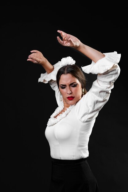 Medium shot lady performing flamenco dance with arms up
