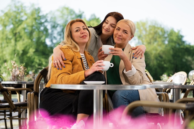 Foto gratuita famiglia lgbtqi del colpo medio che mangia caffè